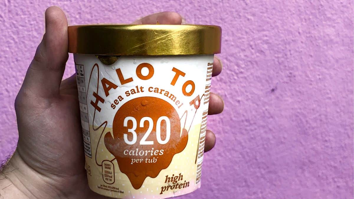 人持有低卡路里品脱冰淇淋紫墙
